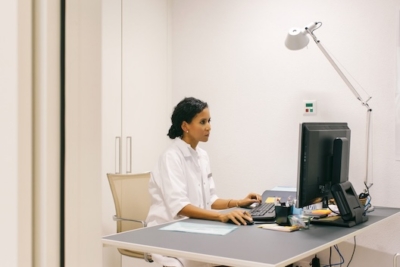 Woman working at a desk with a computer in a modern office setting